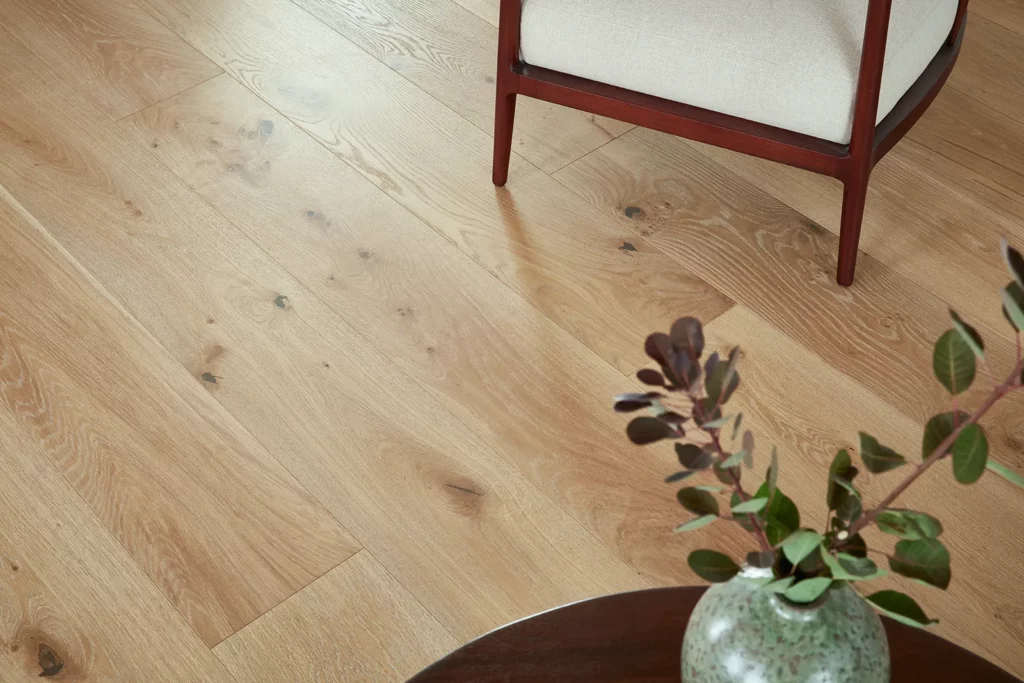 Hardwood flooring overhead with chair and plant on table